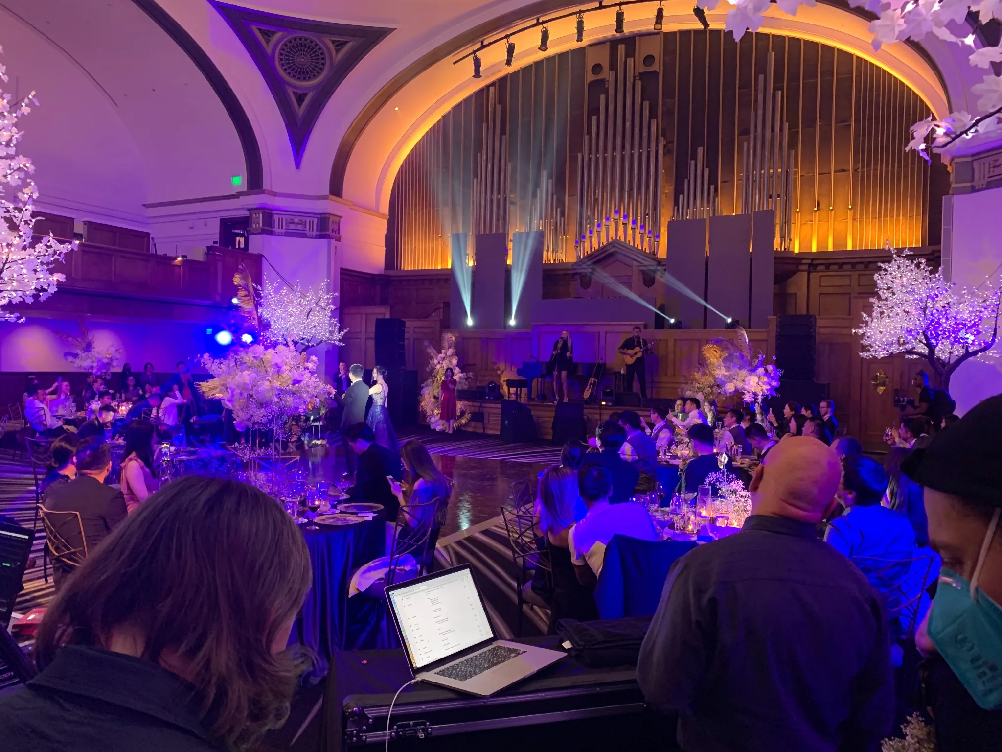 Formal live event in an architectural venue with stage, lighting, performers and seated guests